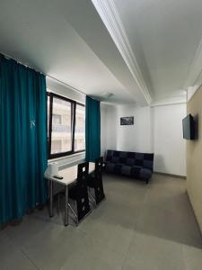 Una sala de estar con un sofá, una mesa y sillas. en studio Mamaia Solid Residence, en Mamaia