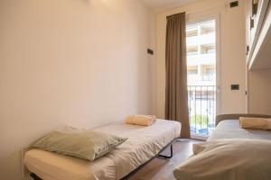two beds in a room with a window at Ava home - apartment in the center Camonica Valley in Boario Terme +35 photos
