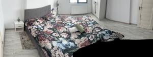 Un dormitorio con una cama con una colcha floral. en Mall Residence, en Văleni