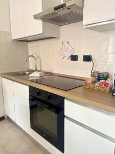 een keuken met een spoelbak en een fornuis bovenste oven bij Perla Apartment Verona in Verona