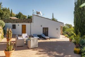 a patio with chairs and a white building at Casa Chica by Rosas Cantares in Pizarra +2 photos