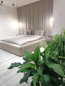 a bedroom with a bed with green plants at 2к шикарний люкс! in Khmelʼnytsʼkyy