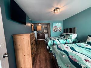 two beds in a room with blue walls at Twilight Motel in Wildwood +133 photos