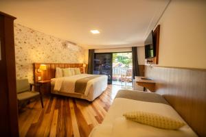 a hotel room with two beds and a balcony at Pousada Santa Felicidade in Campos do Jordão +135 photos