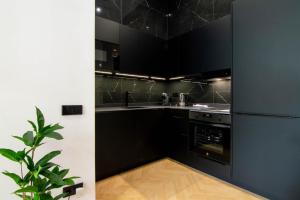 a black kitchen with a sink and a stove at Luxe Appartement in Valencia - Dichtbij strand in Valencia