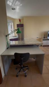 a desk with a lamp and a chair in a room at Apartamento confortable en Mazagón in Mazagón +8 photos