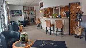 Eine Bar in einem Salon mit Stühlen und einem Tresen in der Unterkunft Logis Hotel Le Cerf in Briare