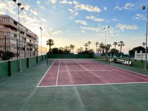 een tennisbaan met palmbomen op de achtergrond bij The house of secrets in Torrevieja