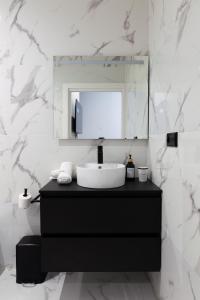 a bathroom with a sink and a mirror at Luxe Appartement in Valencia - Dichtbij strand in Valencia +11 photos