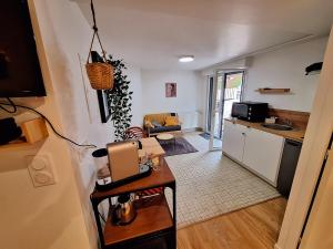 a kitchen and a living room with a table at Charmant studio calme & cosy Rennes in Rennes
