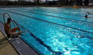 a swimming pool with people in the water at Charmant studio calme & cosy Rennes in Rennes