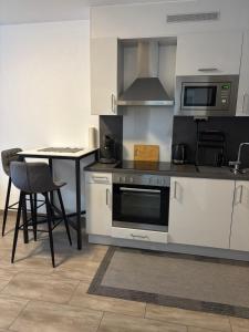 a kitchen with a stove and a microwave and a table at Ferienwohnung Konstanz in Konstanz