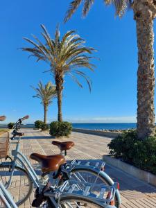 a bike parked on a sidewalk next to the beach at Luxe Appartement in Valencia - Dichtbij strand in Valencia