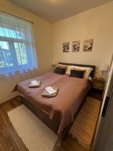 a bedroom with a large bed with two towels on it at Vadvirág Vendégház Gárdony in Gárdony +13 photos