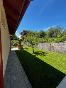 a backyard with a fence and a grass yard at Vadvirág Vendégház Gárdony in Gárdony