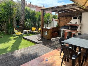 a patio with a grill and a table and chairs at villa de canet 66 in Canet-en-Roussillon