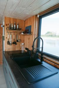 a kitchen with a sink and a window at La cabane a fleur d eau au cœur de la Camargue in Saint-Gilles +19 photos