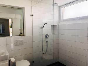 a bathroom with a shower and a toilet and a window at Ferienwohnen im Ziegelfeld in Niederrotweil +40 photos