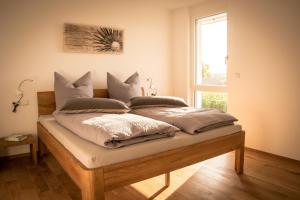 a bed with pillows on it in a room with a window at Ferienwohnen im Ziegelfeld in Niederrotweil
