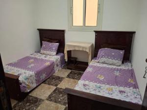 a room with two beds and a table and a window at شقة على البحر- Seafront Apartment in El Delr