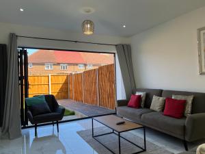 a living room with a couch and a table at Brand New, Immaculate 3 Bed 3 Shower room House in Cheshunt