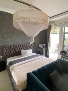 a bedroom with a large bed and a large chandelier at TWIGER HOUSE by WILSON in Kigali