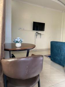 a table and a chair with a vase of flowers on it at TWIGER HOUSE by WILSON in Kigali