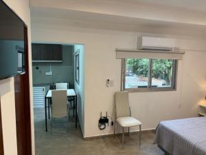 a room with a bed and a kitchen with a table at Emperatriz I in Posadas