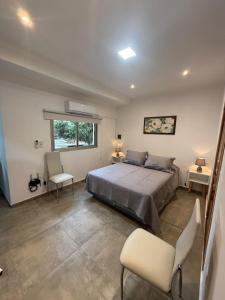 a bedroom with a bed and two chairs and a window at Emperatriz I in Posadas