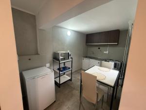 a small kitchen with a table and a refrigerator at Emperatriz I in Posadas