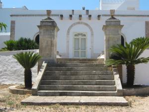 a set of stairs in front of a building with palm trees at Masseria Rienzo in Ostuni