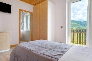 Un dormitorio con una cama y una ventana grande en Agritur Montibeller Fravort, en Marter di Roncegno