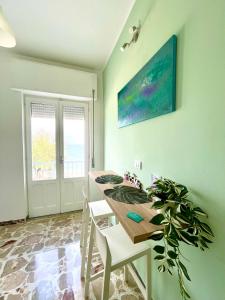 a dining room with a table and a potted plant at Acquamarina B&B Deluxe in Cariati