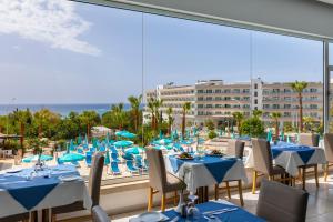a restaurant with tables and chairs and a view of the beach at Cyprotel Florida in Ayia Napa