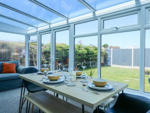 a dining room with a table and some windows at Hendre in Abergele