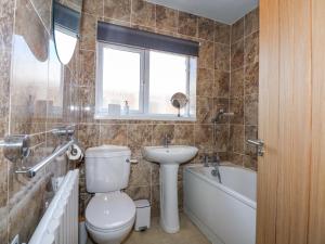 a bathroom with a toilet and a sink and a tub at Hendre in Abergele +19 photos