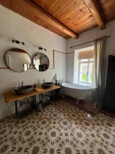 a bathroom with two sinks and a tub and a mirror at Lelle Cottage in Balatonlelle +34 photos