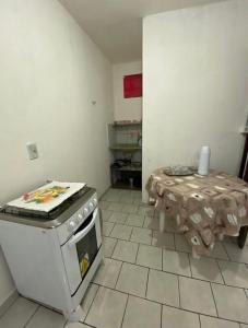 a kitchen with a stove and a table in it at kitnet bem localizado in João Pessoa
