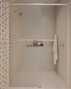 a white bathroom with a shower and a shower curtain at Fátima's Place - Cozy Loft in Old Town Viana in Viana do Castelo