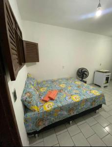 a bedroom with a bed with a blue comforter at kitnet bem localizado in João Pessoa +7 photos