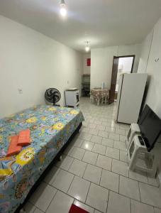 a bedroom with a bed and a flat screen tv at kitnet bem localizado in João Pessoa