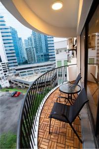 a balcony with a table and chairs on a balcony at Downtown Condo KL City - 18 pax in Kuala Lumpur