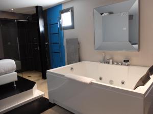 een witte badkamer met een bad en een spiegel bij Be Loft B&B Pool & Spa in Avignon