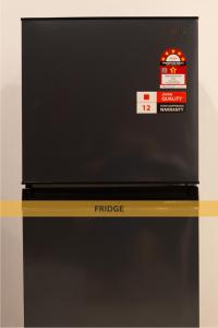 a black refrigerator with a price sign on it at Downtown Condo KL City - 18 pax in Kuala Lumpur