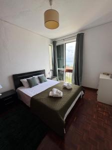 a bedroom with a bed with two towels on it at América Apartment Holiday in Funchal +12 photos