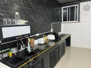 a kitchen with a counter with a sink and a tv at Anda Mantham Hill in Ban Bang Rong