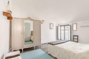 a bedroom with a large dresser with a mirror at Casas da Colmeia T1 Grey Stairs in Reguengos de Monsaraz