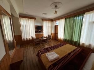 a bedroom with a large bed and a table at Mountain Face cottage and Resort in Manāli