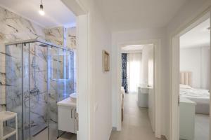 a bathroom with a walk in shower and a sink at Luxury Sea View Apartments in Sarandë +46 photos