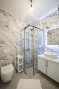 a bathroom with a shower and a toilet and a sink at Luxury Sea View Apartments in Sarandë